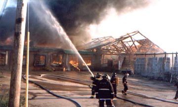 Unidentified firefighters douse the fire with water.