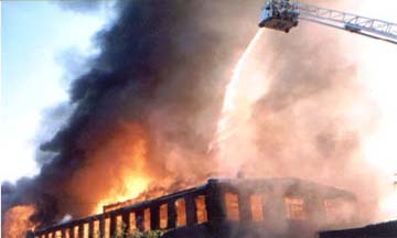 Firefighters in a Snorkel bucket douse the flames from above.